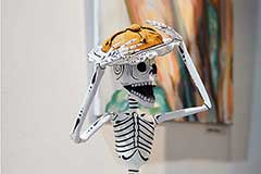 skulptur eines skelettes auf totenkopf sitzend
